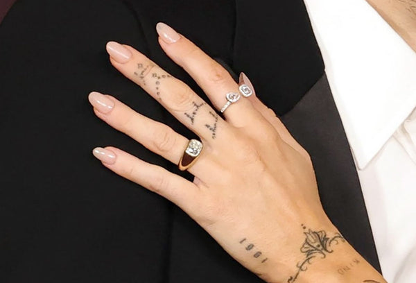 close up of miley cyrus hand wearing thick chunky cigar band engagement ring