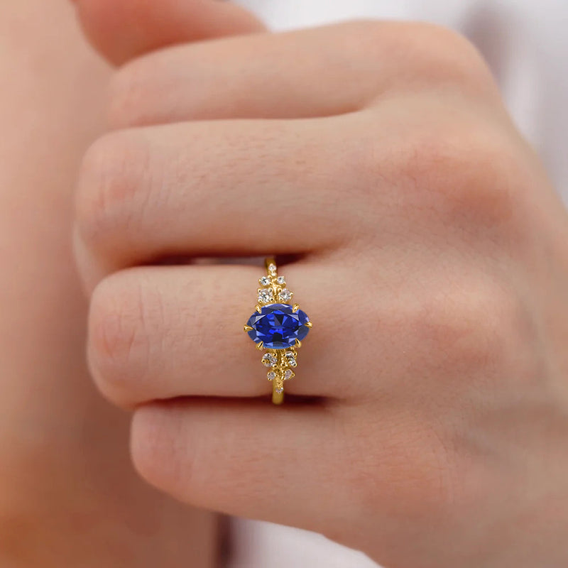 ALYA - Chatham® Oval Blue Sapphire Starburst Cluster Shoulder Set Engagement Ring 18k Yellow Gold