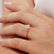 Round gemstone engagement ring, worn on a model's hand.