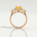 Blossom trilogy engagement ring in 18k rose gold with a round yellow lab-grown sapphire centre stone and pear-shaped diamond side stones, side profile showing the setting and band.