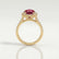 Cecily halo engagement ring in 18k yellow gold with a round lab-grown ruby centre stone and diamond accents, side profile showing the setting and band.