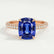 Coco hidden halo engagement ring in 18k rose gold with an elongated cushion blue lab-grown sapphire centre stone on a triple pavé band, front view.