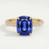Coco hidden halo engagement ring in 18k yellow gold with an elongated cushion blue lab-grown sapphire centre stone on a triple pavé band, front view.