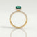 Coco hidden halo engagement ring in 18k yellow gold with an elongated cushion lab-grown emerald centre stone on a triple pavé band, side profile showing the setting and band.