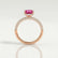 Coco hidden halo engagement ring in 18k rose gold with an elongated cushion pink lab-grown sapphire centre stone on a triple pavé band, side profile showing the setting and band.