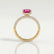 Coco hidden halo engagement ring in 18k yellow gold with an elongated cushion pink lab-grown sapphire centre stone on a triple pavé band, side profile showing the setting and band.