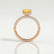 Coco hidden halo engagement ring in 18k rose gold with an elongated cushion yellow lab-grown sapphire centre stone on a triple pavé band, side profile showing the setting and band.