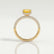 Coco hidden halo engagement ring in 18k yellow gold with an elongated cushion yellow lab-grown sapphire centre stone on a triple pavé band, side profile showing the setting and band.