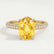 Coco hidden halo engagement ring in 18k yellow gold with an oval yellow lab-grown sapphire centre stone and diamond accents on a triple pavé band, front view.