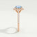 Darley halo engagement ring in 18k rose gold with an elongated cushion aquamarine-blue lab-grown sapphire centre stone, end-on view showing the setting and band.