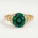 Delilah shoulder-set engagement ring in 18k yellow gold with a round lab-grown emerald centre stone, front view.