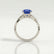 Eden vine solitaire engagement ring with an oval blue lab-grown sapphire centre stone and diamond accents, side profile showing the setting and band.