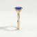 Eden vine solitaire engagement ring in 18k yellow gold with an oval blue lab-grown sapphire centre stone and diamond accents, end-on view showing the setting and band.