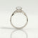Eden vine solitaire engagement ring in 18k white gold with an oval moissanite centre stone and diamond accents, side profile showing the setting and band.
