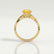 Eden vine solitaire engagement ring in 18k yellow gold with an oval yellow lab-grown sapphire centre stone and diamond accents, side profile showing the setting and band.