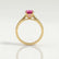 Elena solitaire engagement ring in 18k yellow gold with a round pink lab-grown sapphire centre stone, side profile showing the setting and band.