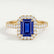 Esme halo engagement ring in 18k yellow gold with an emerald-cut blue lab-grown sapphire centre stone and diamond accents, front view.