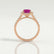 Esme halo engagement ring in 18k rose gold with an emerald-cut pink lab-grown sapphire centre stone and diamond accents, side profile showing the setting and band.