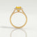 Esme halo engagement ring in 18k yellow gold with a radiant yellow lab-grown sapphire centre stone and diamond accents, side profile showing the setting and band.