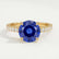 Giselle solitaire engagement ring in 18k yellow gold with a round blue lab-grown sapphire centre stone and diamond accents, front view.