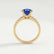 Giselle solitaire engagement ring in 18k yellow gold with a round blue lab-grown sapphire centre stone and diamond accents, side profile showing the setting and band.