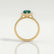 Harlow halo engagement ring in 18k yellow gold with a pear-shaped lab-grown emerald centre stone and diamond accents, side profile showing the setting and band.