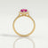 Harlow halo engagement ring in 18k yellow gold with a pear-shaped pink lab-grown sapphire centre stone and diamond accents, side profile showing the setting and band.