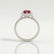 Harlow halo engagement ring in platinum with a pear-shaped lab-grown ruby centre stone and diamond accents, side profile showing the setting and band.