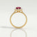 Harlow halo engagement ring in 18k yellow gold with a pear-shaped lab-grown ruby centre stone and diamond accents, side profile showing the setting and band.