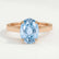 Isabella solitaire engagement ring in 18k rose gold with an oval aquamarine-blue lab-grown sapphire centre stone, front view.
