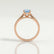 Isabella solitaire engagement ring in 18k rose gold with an oval aquamarine-blue lab-grown sapphire centre stone, end-on view showing the setting and band.