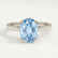 Isabella solitaire engagement ring in 18k white gold with an oval aquamarine-blue lab-grown sapphire centre stone, front view.