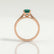 Isabella solitaire engagement ring in 18k rose gold with an oval lab-grown emerald centre stone, end-on view showing the setting and band.