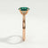 Isabella solitaire engagement ring in 18k rose gold with an oval lab-grown emerald centre stone, side profile showing the setting and band.
