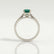 Isabella solitaire engagement ring in platinum with an oval lab-grown emerald centre stone, end-on view showing the setting and band.