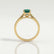 Isabella solitaire engagement ring in 18k yellow gold with an oval lab-grown emerald centre stone, end-on view showing the setting and band.