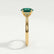 Isabella solitaire engagement ring in 18k yellow gold with an oval lab-grown emerald centre stone, side profile showing the setting and band.