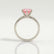 Juliet solitaire engagement ring with a round morganite-pink lab-grown sapphire centre stone, side profile showing the setting and band.