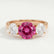 Leanora trilogy engagement ring in 18k rose gold with a round pink lab-grown sapphire centre stone, front view.
