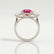 Leanora trilogy engagement ring in 18k white gold with a round pink lab-grown sapphire centre stone, side profile showing the setting and band.