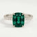 Lively hidden halo engagement ring with an elongated cushion lab-grown emerald centre stone on a pavé-set band, front view.