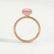 Lively hidden halo engagement ring in 18k rose gold with an oval morganite-pink lab-grown sapphire centre stone on a pavé-set band, side profile showing the setting and band.