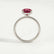 Lively hidden halo engagement ring with an oval lab-grown ruby centre stone on a pavé-set band, side profile showing the setting and band.
