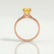 Lottie solitaire engagement ring in 18k rose gold with a round yellow lab-grown sapphire centre stone, side profile showing the setting and band.