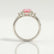 Louella trilogy engagement ring with an oval morganite-pink lab-grown sapphire centre stone, side profile showing the setting and band.