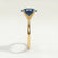 Lulu solitaire engagement ring in 18k yellow gold with an elongated cushion lab-grown alexandrite centre stone, end-on view showing the setting and band.