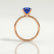 Lulu solitaire engagement ring in 18k rose gold with an elongated cushion blue lab-grown sapphire centre stone, side profile showing the setting and band.