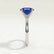 Lulu solitaire engagement ring in 18k white gold with an elongated cushion blue lab-grown sapphire centre stone, end-on view showing the setting and band.