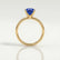 Lulu solitaire engagement ring in 18k yellow gold with an elongated cushion blue lab-grown sapphire centre stone, side profile showing the setting and band.