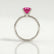 Lulu solitaire engagement ring in 18k white gold with an elongated cushion pink lab-grown sapphire centre stone, side profile showing the setting and band.